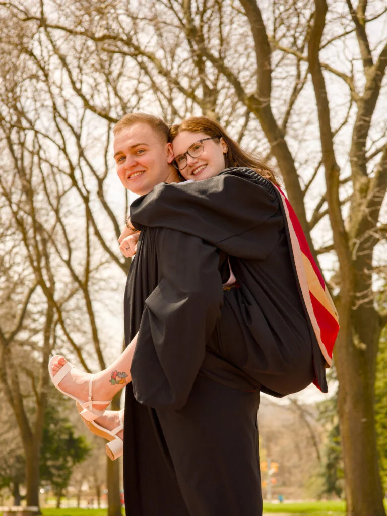 Graduating friends hugging in convocation gowns