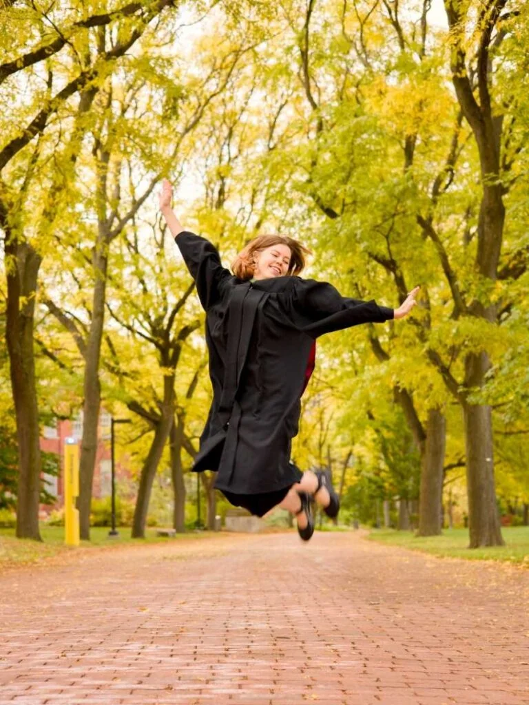 A graduate photographed in the green summer gardens of the University of Guelph Arboretum