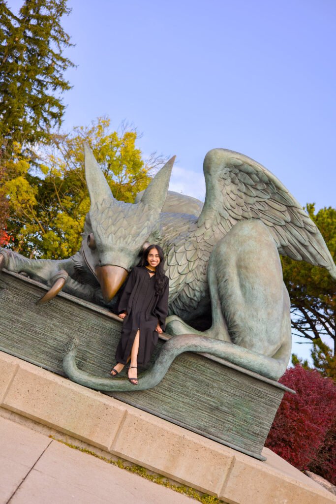 Woman posing with a large green dragon sculpture in an outdoor setting