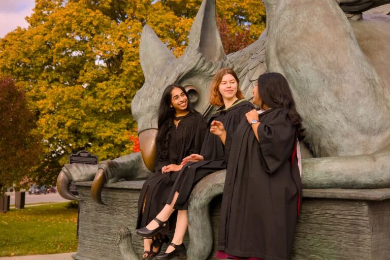 Graduates at the Gryphon Statue at the University of Guelph