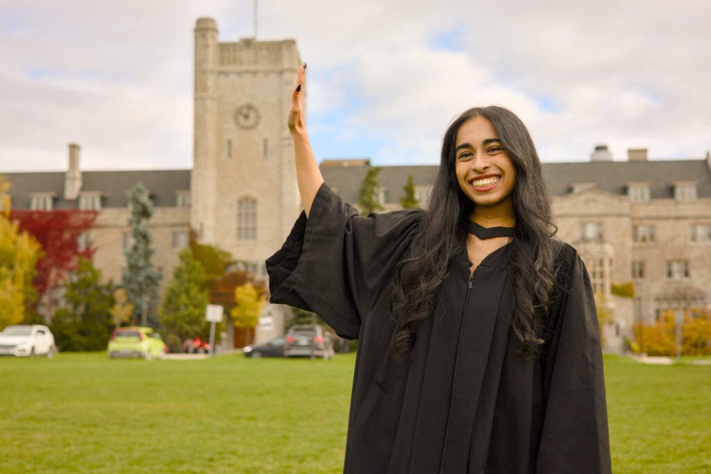 A graduate photographed at Johnston Green and the clock tower at the University of Guelph