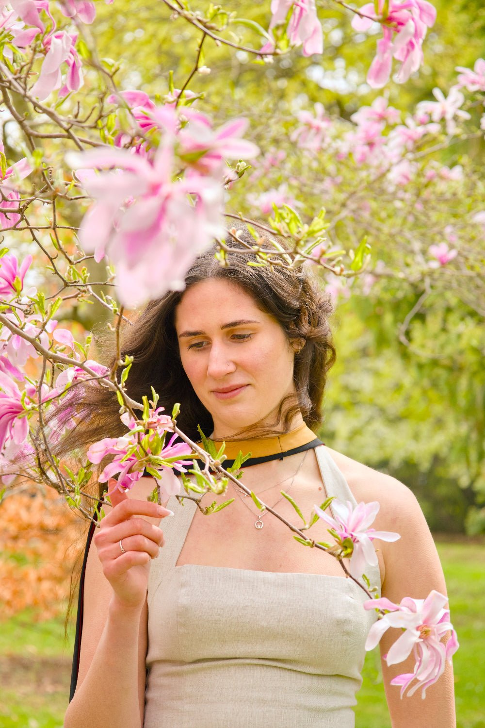 Woman standing among pink flowers in a garden. The photo is from Guelph Grad Photos. The background is the University of Guelph Campus.