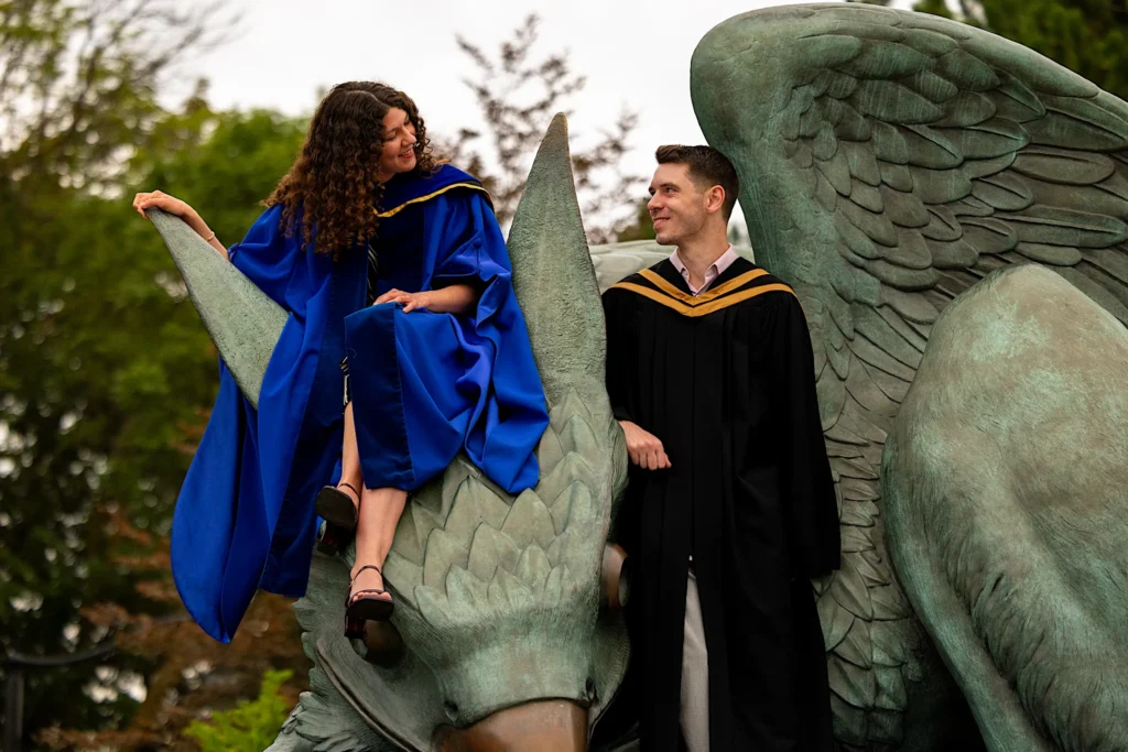 A couple in regalia by the Gryphon statue.