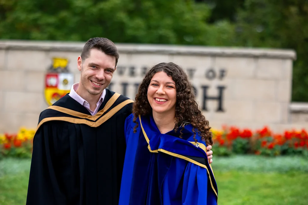 A couple at the University of Guelph entrance sign.