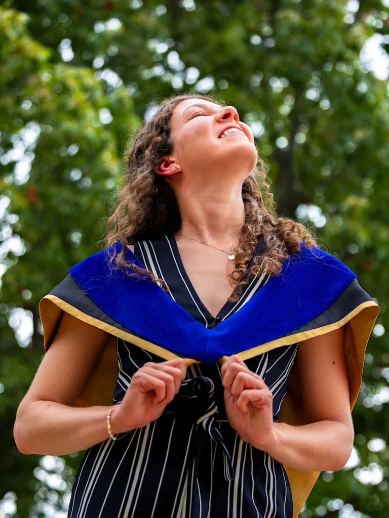 A University of Guelph graduate laughing with her head back, in doctoral regalia.