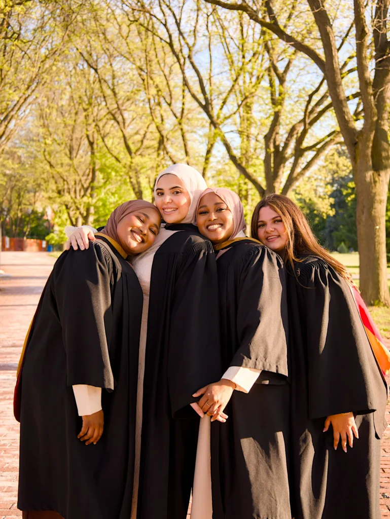 Four University of Guelph graduates together on the tree-lined path.