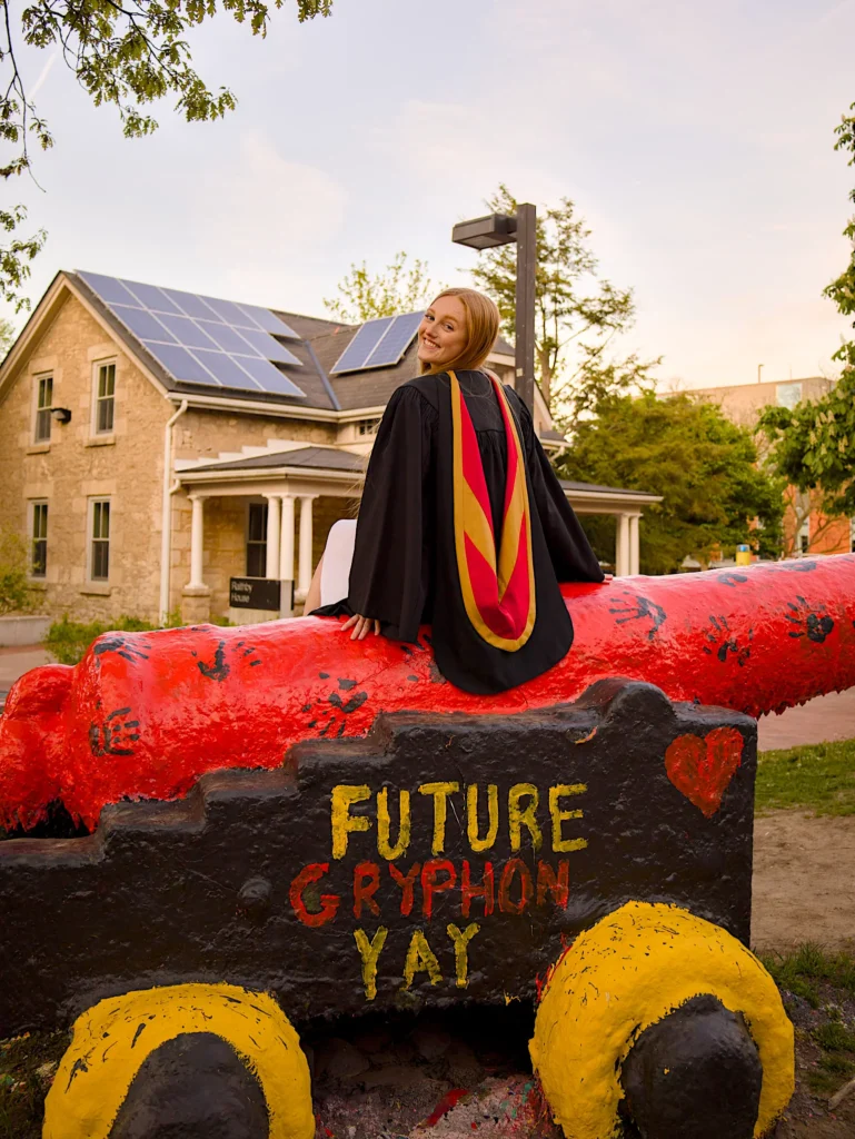 A University of Guelph graduate with her regalia draped over Old Jeremiah.