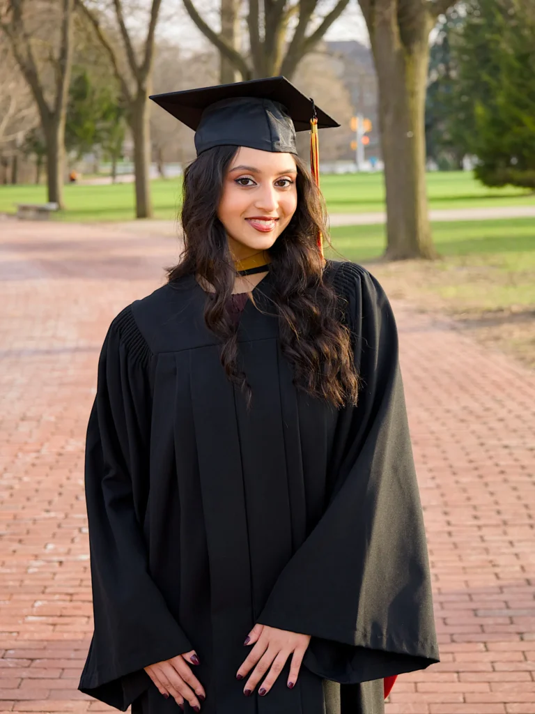 A University of Guelph graduate in cap and regalia on a brick campus path.